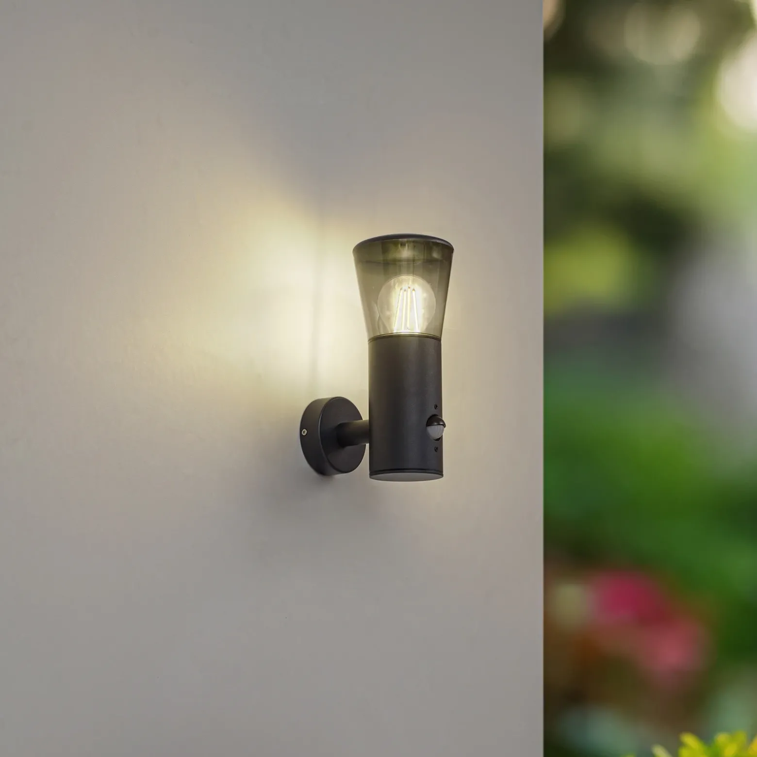 Aplique de exterior Lindby Heulo, Ø 10,5 cm, gris humo, con sensor