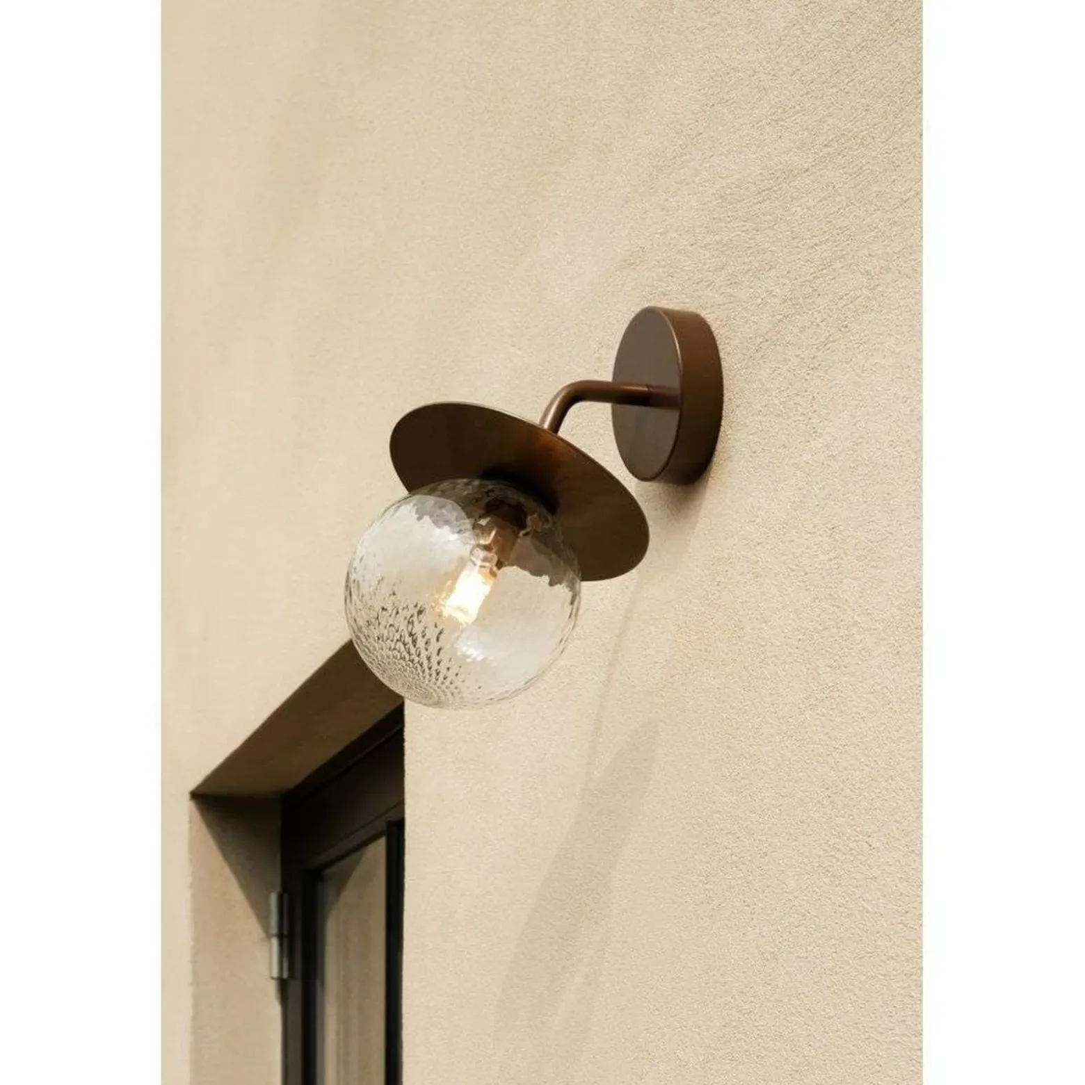 Aplique de exterior Nuura Liila, ancho 16 cm, bronce/transparente