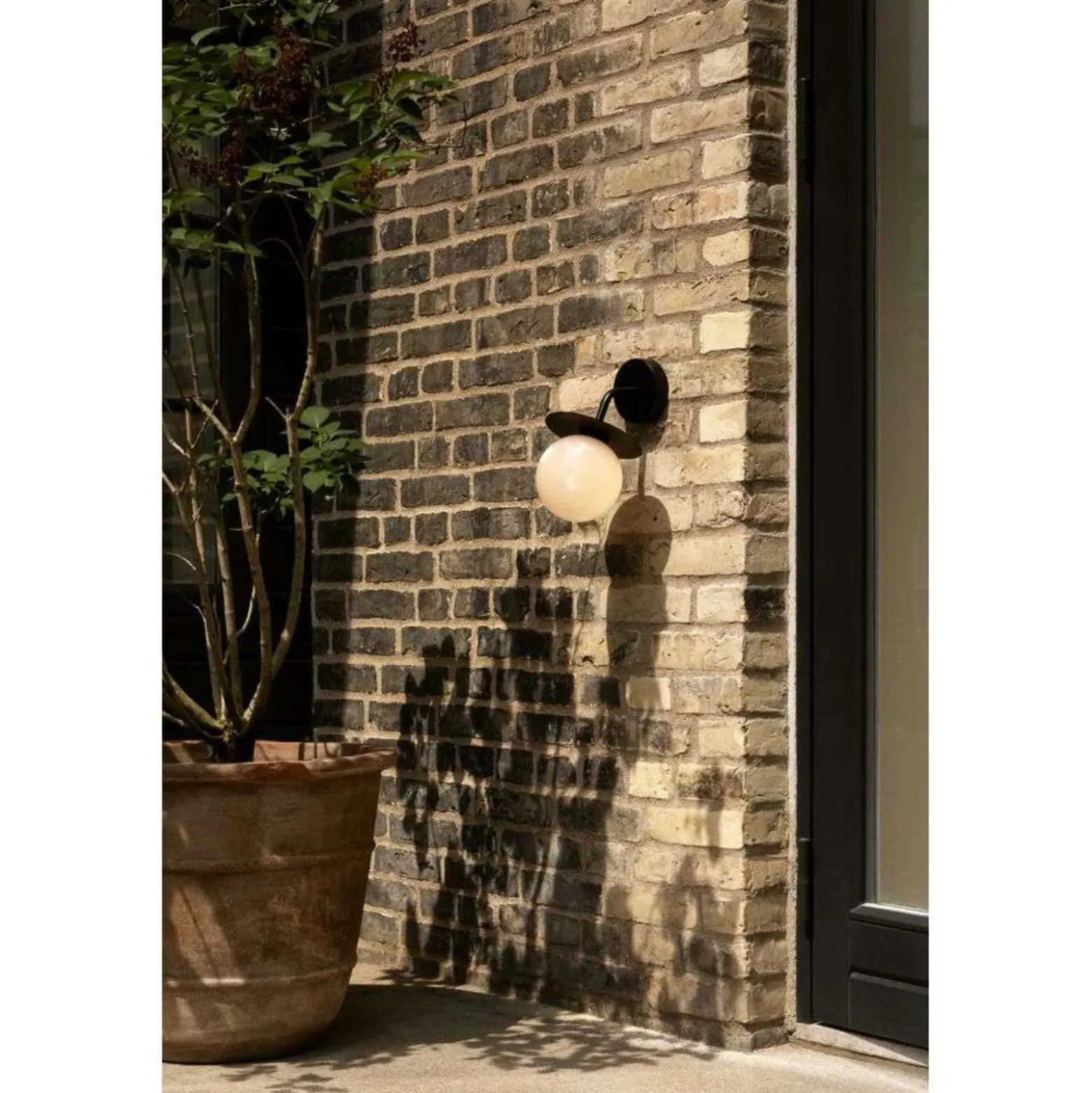 Aplique de exterior Nuura Liila, ancho 16 cm, negro/ópalo