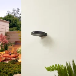 Aplique de pared LED solar Lucande Tavon, redondo, negro, sensor
