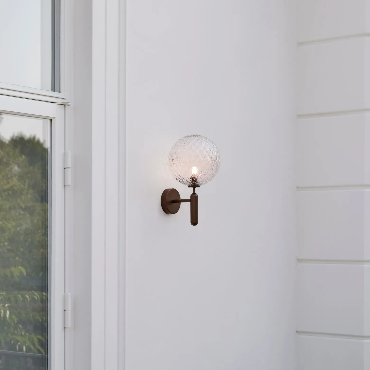 Aplique para exterior Nuura Miira, Ø 20 cm, bronce oscuro/transparente