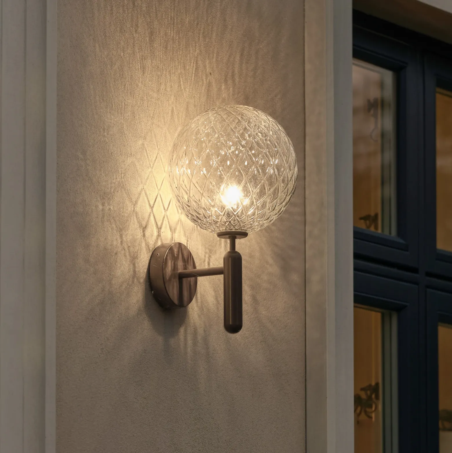 Aplique para exterior Nuura Miira, Ø 20 cm, bronce oscuro/transparente